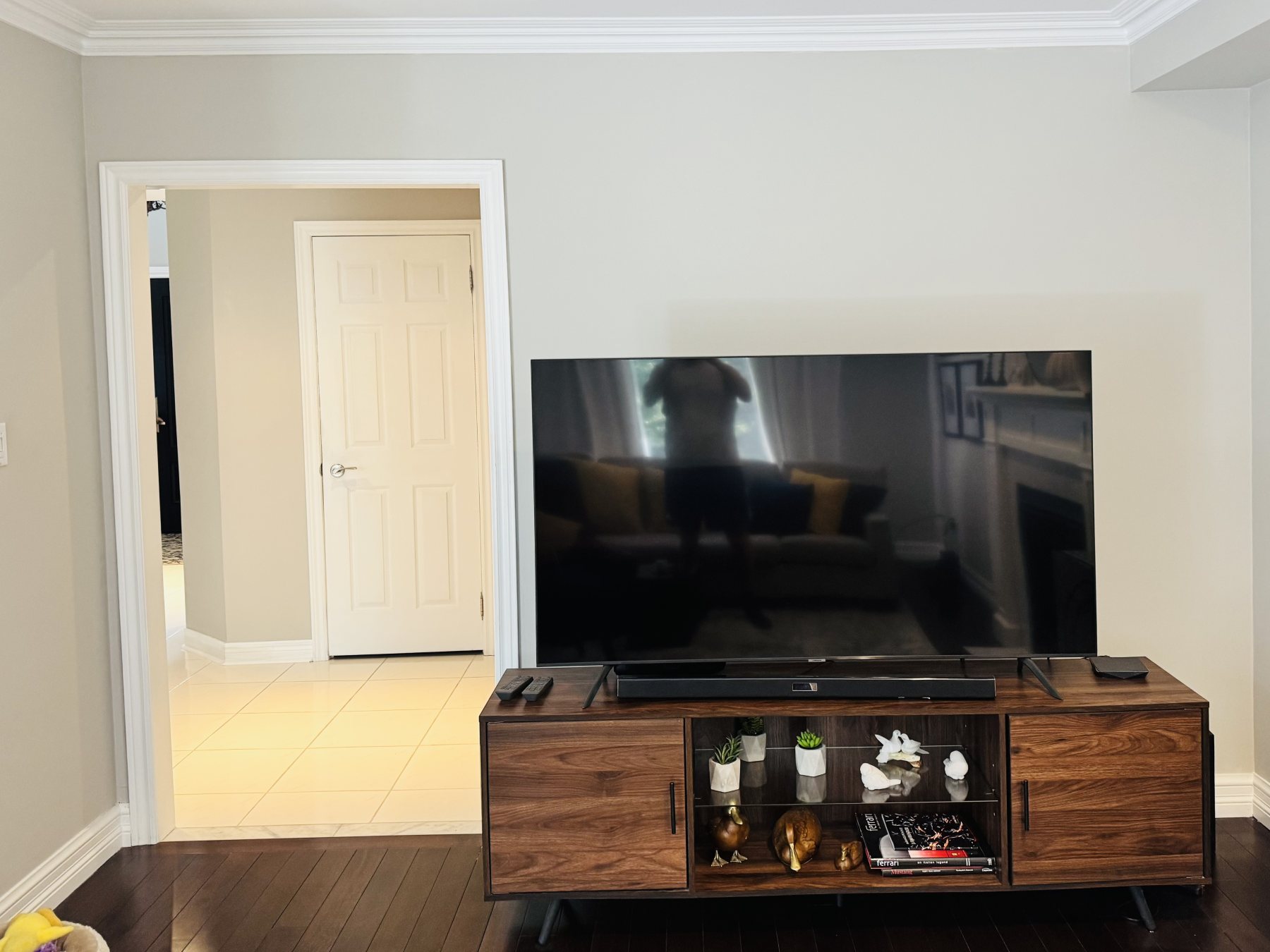 The same living room before the install: a plain beige painted wall behind the television.