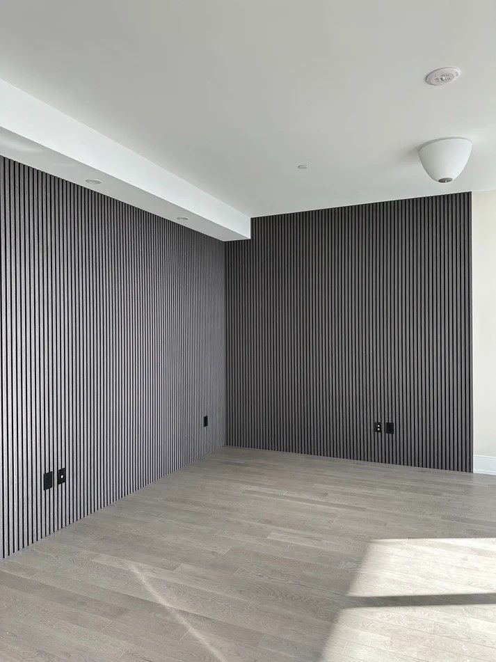 Empty room with charcoal slat panelling wrapping two full walls and returning around the corner.